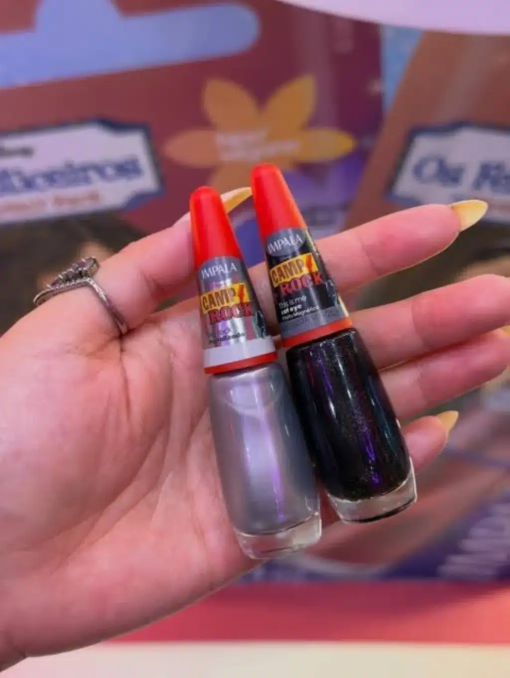 Esmaltes Impala Camp Rock em tubos vermelhos e pretos, com cores brilhantes, mostrados na mão.