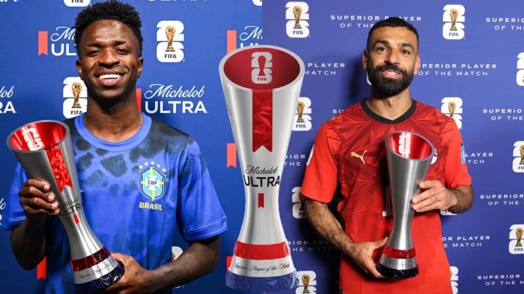 Jogadores do Brasil e da equipe masculina seguram troféus de melhor da partida em evento da FIFA, em cenário “Michelob ULTRA”.