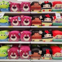 Prateleira com pelúcias quadradas colecionáveis de personagens da Disney e Marvel, com destaque para faces e formatos quadrados