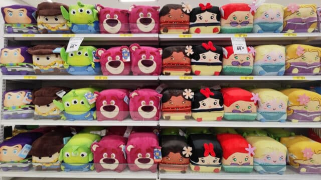 Prateleira com pelúcias quadradas colecionáveis de personagens da Disney e Marvel, com destaque para faces e formatos quadrados