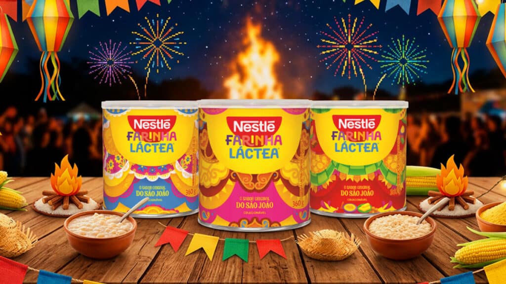 Latas da Farinha Láctea Nestlé em embalagens de Festa Junina, com mesa decorada e fogueira ao fundo.