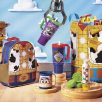 Coleção Toy Story 5 da Avon e Casa & Estilo com mochila, marmita, canecas e cosméticos infantis sobre cenário azul