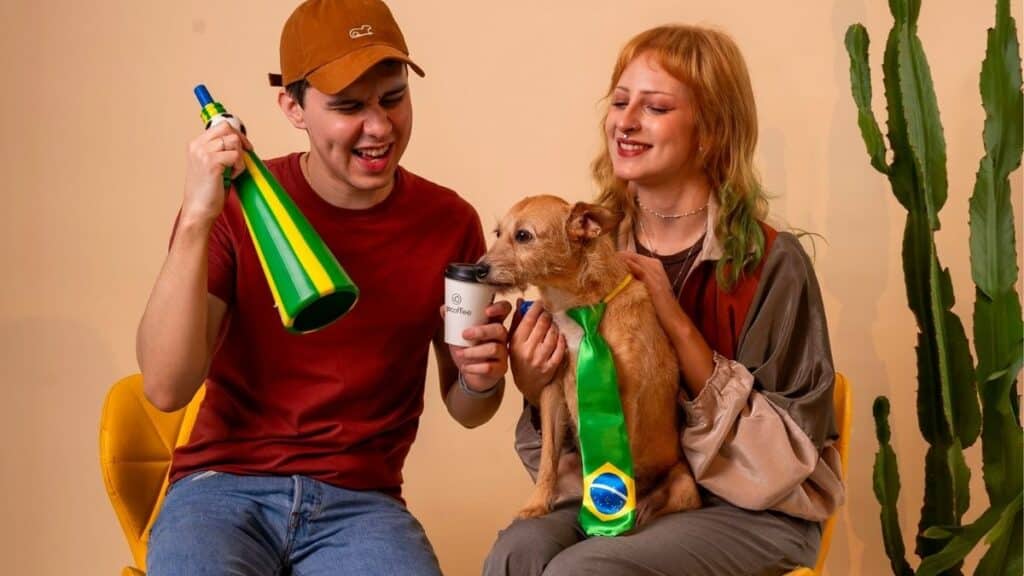 Casal e cachorro com lata de café e garrafa verde, em clima de campanha Go Coffee caramelo.