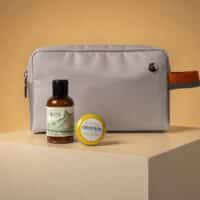 Kit exclusivo da GOL e Granado com necessaire e frascos de cosméticos sobre pedestal, em fundo claro.