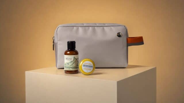 Kit exclusivo da GOL e Granado com necessaire e frascos de cosméticos sobre pedestal, em fundo claro.