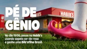 Chuteira cor-de-rosa do Habib’s sobre grama com fachada da loja ao fundo e texto promocional em destaque.