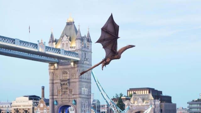 Syrax em voo sobre Londres, com o dragão próximo à Tower Bridge durante ação promocional do HBO Max
