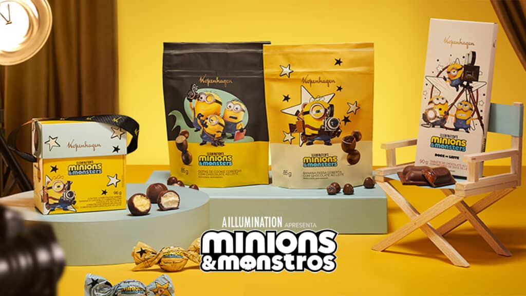 Embalagens de chocolates Kopenhagen Minions & Monstros, com personagens dos Minions e tabletes e drágeas na mesa.