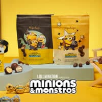 Embalagens de chocolates Kopenhagen Minions & Monstros, com personagens dos Minions e tabletes e drágeas na mesa.