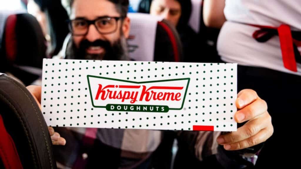 Passageiro segurando caixa de donut Krispy Kreme em voo, em parceria com a LATAM Airlines