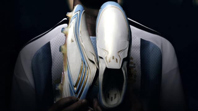 Chuteiras da Adidas da coleção 'El Último Tango' brancas e azuis em destaque, associadas à Copa do Mundo de Lionel Messi