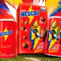 Embalagens do Nescau em edição limitada com tema de futebol e cores vibrantes, em cenário de estádio.