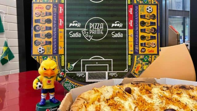 Pizza Prime com pizza assada em caixa e exibição de canarinho colecionável do Guaraná Antarctica ao lado