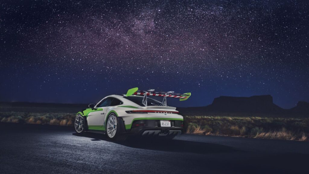 Porsche 911 inspirado em Buzz Lightyear, com pintura verde e branca, em estrada à noite sob estrelas