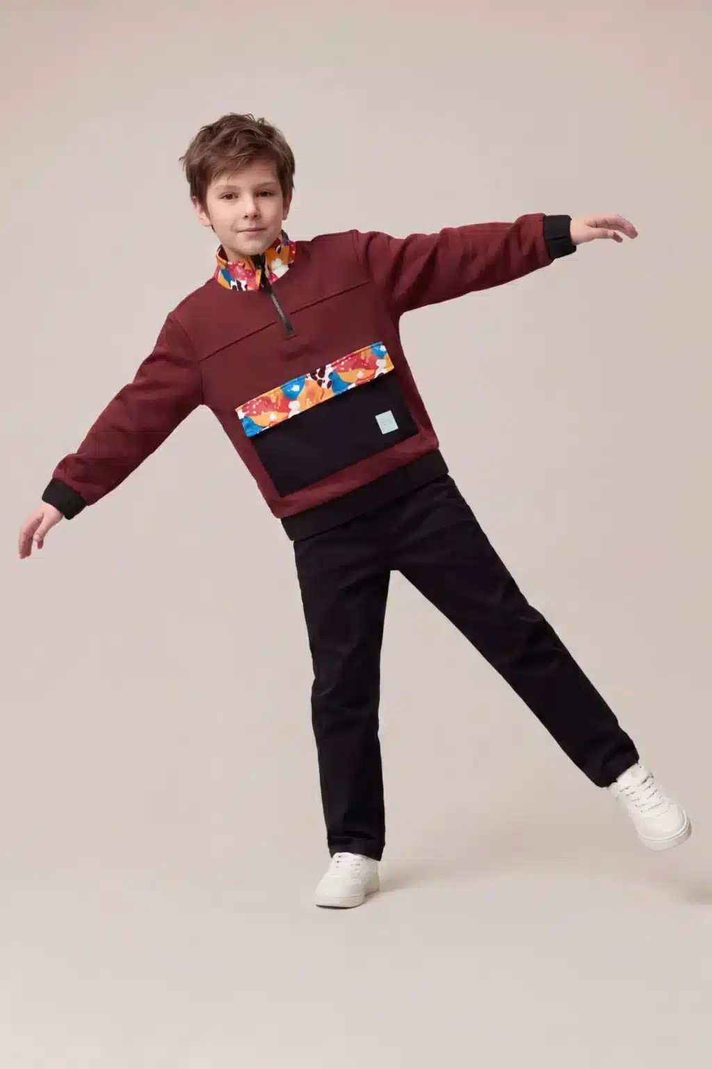Criança em pose de dança usando casaco bordô e camiseta colorida, em destaque na campanha Disney Extraimaginário
