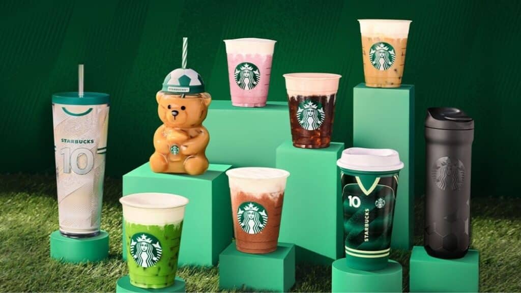 Linha de bebidas da Starbucks com Cold Foam Proteico em copos e acessórios sobre fundo verde