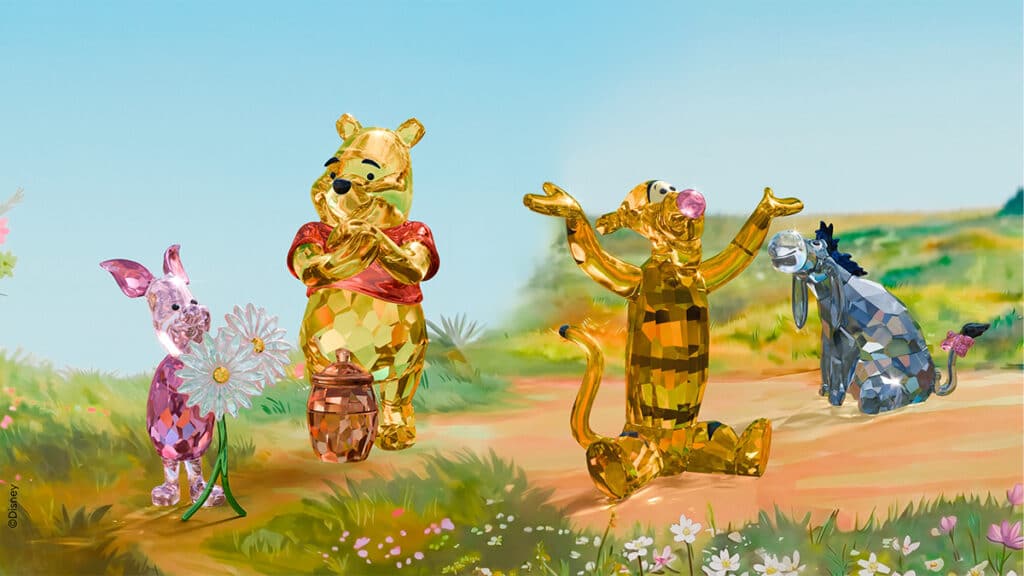 Esculturas em cristal inspiradas no Ursinho Pooh: Pooh, Leitão e Tigrão em cenário do Bosque dos Cem Acres.