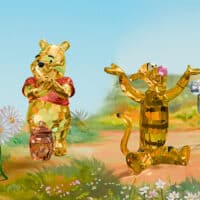 Esculturas em cristal inspiradas no Ursinho Pooh: Pooh, Leitão e Tigrão em cenário do Bosque dos Cem Acres.