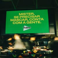Painel no Aeroporto Internacional Tom Jobim com mensagem da Trident e pista sobre a Seleção Brasileira