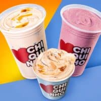 Copos de produtos proteicos com sabores branco e rosa, da parceria Chiquinho e Growth.