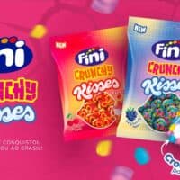 Embalagens de bala Fini Crunchy Risses com textura crocante e recheio macio, no fundo rosa com confetes e a marca Fini