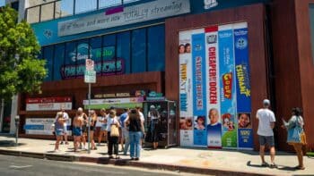Pop-up nostálgica Disney+ e Hulu em Los Angeles Fachada de pop-up da Disney+ e Hulu em Los Angeles, com painéis coloridos e pessoas em frente.