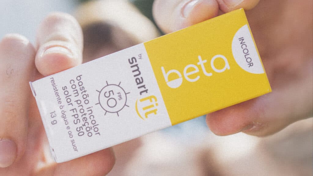 Beta & Smart Fit FPS 50: protetor solar em bastão Cartões do protetor solar Beta & Smart Fit FPS 50, edição limitada em bastão incolor, com rótulos em mãos.