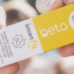 Cartões do protetor solar Beta & Smart Fit FPS 50, edição limitada em bastão incolor, com rótulos em mãos.