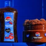 Produtos Glamlite e Pepsi: body wash de Wild Cherry e body scrub Vanilla Slushie, em embalagem azul.