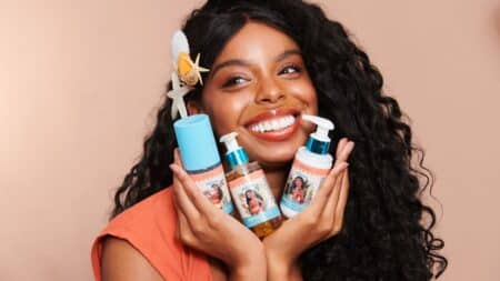 Skincare Miss Rôse inspirada em Moana Mulher sorrindo segura frascos de skincare da coleção Miss Rôse inspirada em Moana