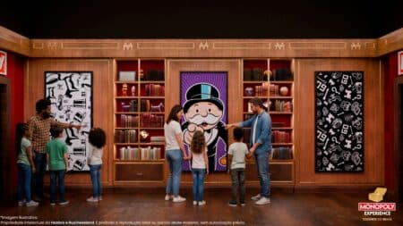 Pessoas interagem em atração imersiva do Monopoly Experience, em ambiente com cenários e murais decorativos.