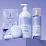 Produtos da linha Cuide-se Bem Lavandinha, com frasco de sabonete líquido, creme e embalagem ao fundo, da marca O Boticário.