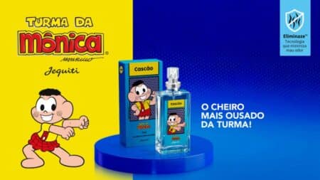 Perfume Cascão Jequiti inspirado na Turma da Mônica Anúncio do perfume Cascão da Jequiti, inspirado na Turma da Mônica, com frasco sobre pedestal azul.
