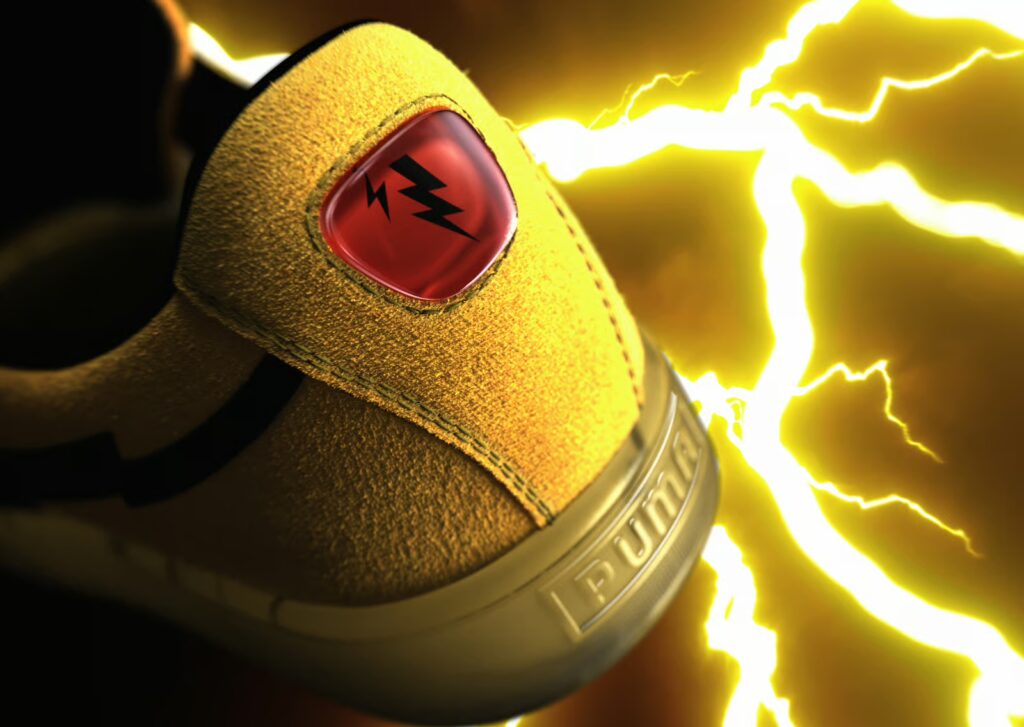 Tênis Puma Suede amarelo com detalhes do Pikachu e marca PUMA em destaque, ao fundo com brilho elétrico amarelo