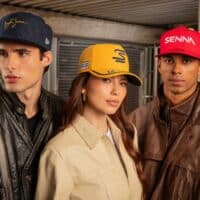 Três modelos usam bonés estilo Senna com a marca New Era, em ambiente urbano.