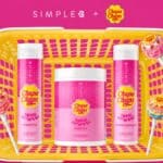 Kit de produtos capilares Simple B + Chupa Chups com frascos e embalagem amarela sobre fundo rosa