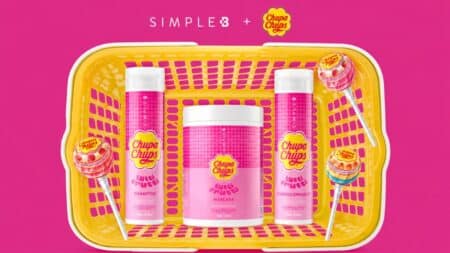 Simple B + Chupa Chups: kit de produtos capilares Kit de produtos capilares Simple B + Chupa Chups com frascos e embalagem amarela sobre fundo rosa