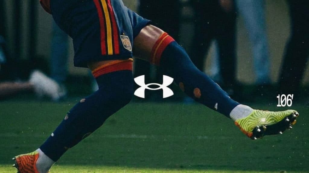 Chuteira Under Armour em ação na Copa do Mundo Chuteira de futebol em ação durante partida, com o logo Under Armour no calçado e número 106 na imagem.