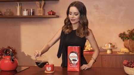 Sandy com Café União em campanha de Café Torrado e Moído Sandy posa com uma embalagem do Café União em cenário de cozinha, preparando a bebida