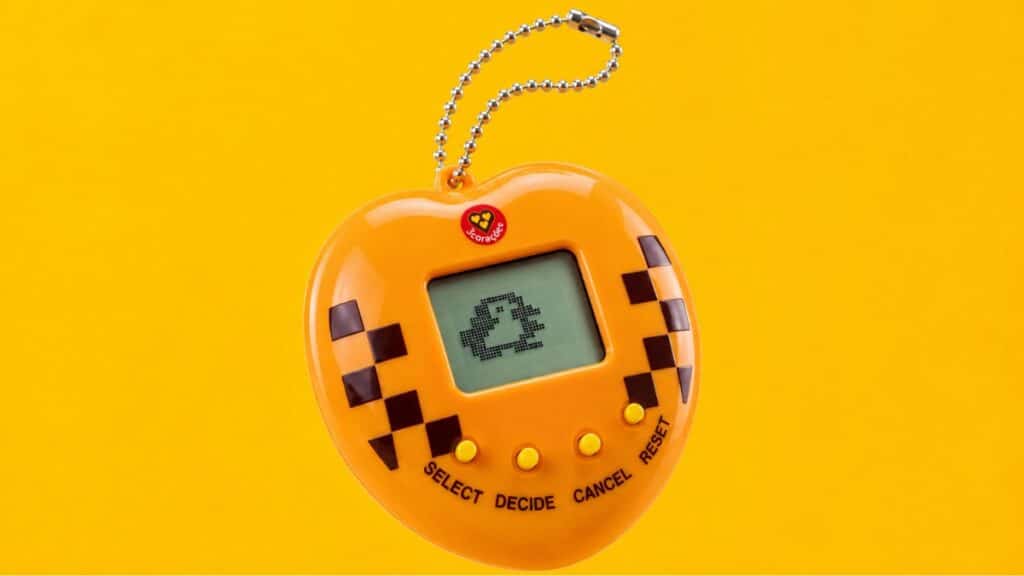 Tamagotchi 3 Corações exclusivo no Rock in Rio 2026 Tamagotchi exclusivo 3 Corações no Rock in Rio 2026, com tela e botões em design amarelo e xadrez