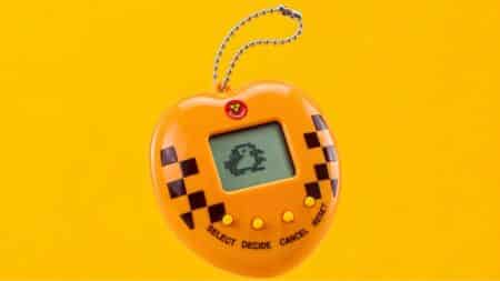 Tamagotchi 3 Corações exclusivo no Rock in Rio 2026 Tamagotchi exclusivo 3 Corações no Rock in Rio 2026, com tela e botões em design amarelo e xadrez