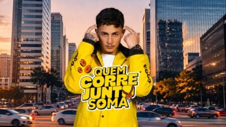 MC Hariel na campanha “Quem Corre Junto Soma” da 99 MC Hariel em avenida de cidade ao pôr do sol, usando jaqueta amarela com texto “QUEM CORRE JUNTO SOMA”.