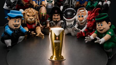Brahma mascote com taça de cerveja dourada Brahma mascote e outros mascotes ao redor de uma taça de cerveja dourada, em clima de promoção