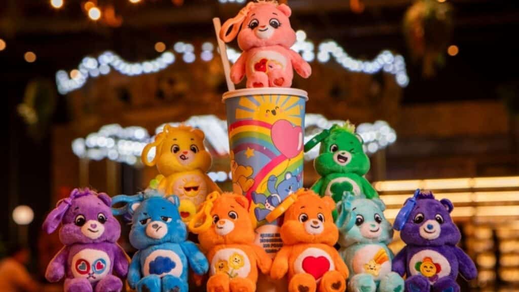 Copo surpresa da Cacau Show com personagens dos Ursinhos Carinhosos ao lado de pelúcias coloridas