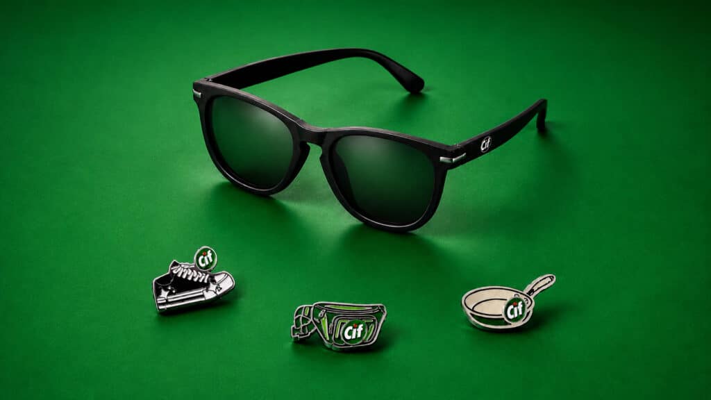 Óculos escuros e brindes da marca Cif sobre fundo verde, em ativação do Rock in Rio 2026 na Cidade do Rock.