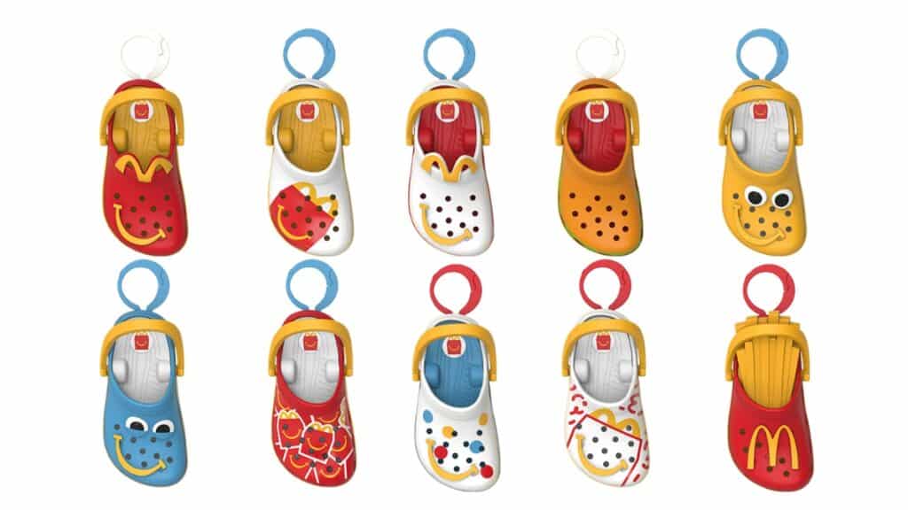 Chinelos Crocs estilo McLanche Feliz em miniaturas penduradas, com temas do McDonald's, em cores variadas.