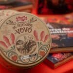Lata Docile “Os Peixinhos do Vovô” ao lado de embalagens e doces em mesa decorada.