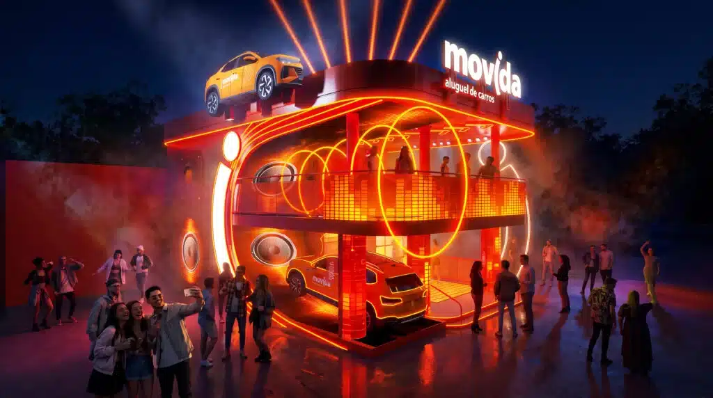 Estande iluminado da Movida no Rock in Rio 2026, com pessoas caminhando na Cidade do Rock ao entardecer