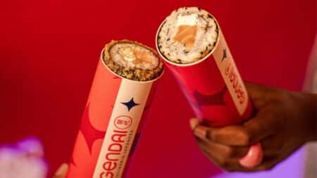Gendai Push Pop em cones com recheios Pessoas seguram cones do Gendai com Push Pop, em vermelho, com recheios no interior do cone.