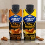 Embalagens da bebida proteica vegetal Almond Breeze 15g proteína, nos sabores Caramelo Salgado e Manga com Maracujá.